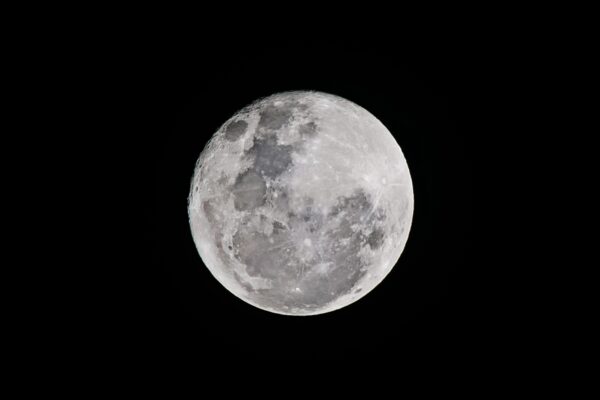Detailed full moon captured against a black sky, showcasing lunar textures.